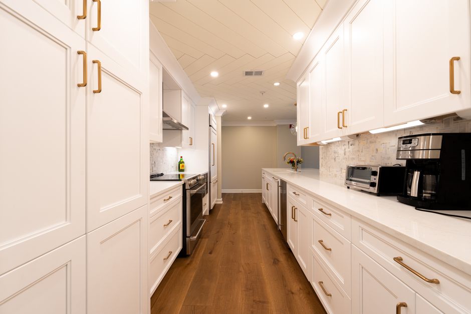 Modern renovated kitchen with white cabinetry and granite countertops